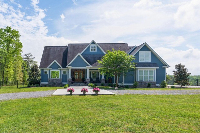craftsman house featuring a porch, a front lawn, and stone siding