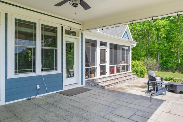view of patio / terrace with ceiling fan and a sunroom