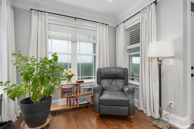 sitting room with crown molding, baseboards, a healthy amount of sunlight, and wood finished floors