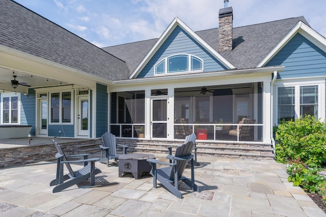 rear view of house featuring a ceiling fan, a patio, a chimney, and an outdoor fire pit