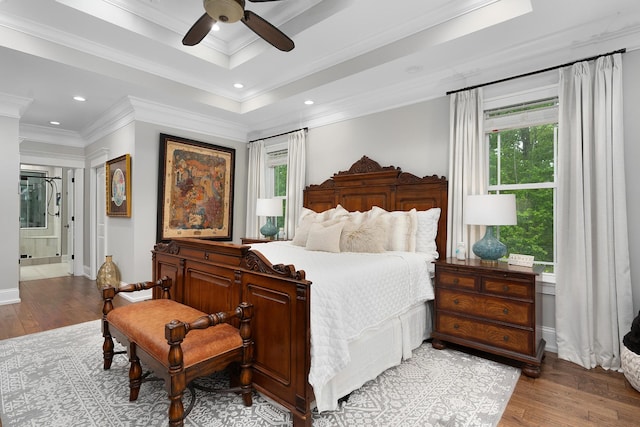 bedroom featuring crown molding, baseboards, multiple windows, and wood finished floors