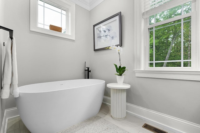 bathroom with baseboards, a wealth of natural light, and tile patterned flooring