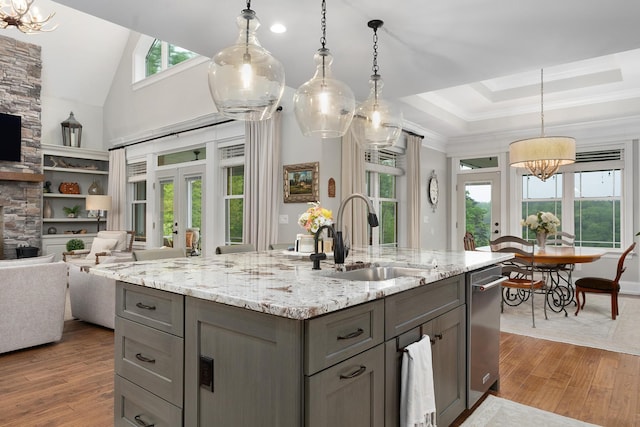 kitchen with wood finished floors, open floor plan, gray cabinets, a chandelier, and a sink