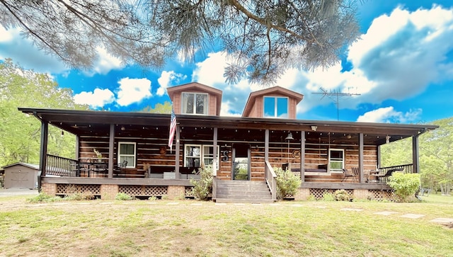 view of front of home featuring a storage unit, an outdoor structure, covered porch, and a front yard
