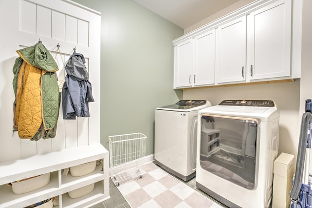 laundry room featuring cabinet space, washing machine and clothes dryer, light floors, visible vents, and baseboards