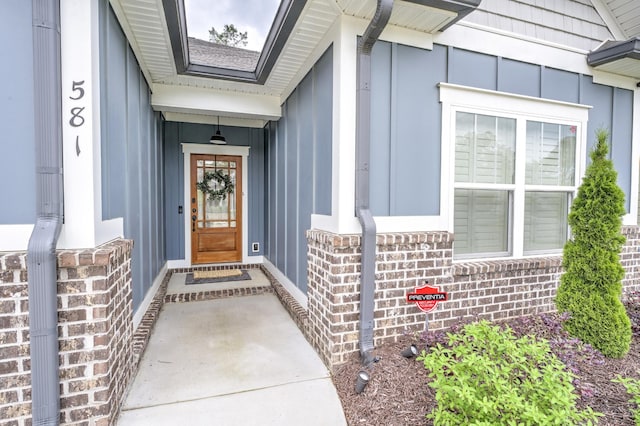 view of exterior entry with brick siding and board and batten siding