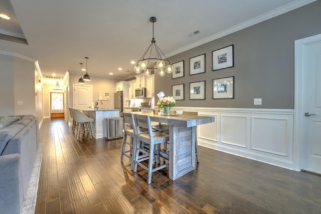dining area with crown molding, recessed lighting, and dark wood-style floors