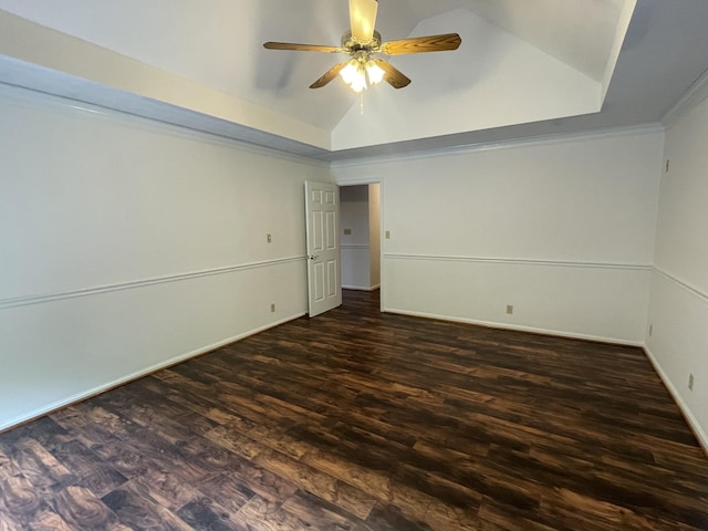 spare room featuring ornamental molding, baseboards, ceiling fan, dark wood-type flooring, and vaulted ceiling