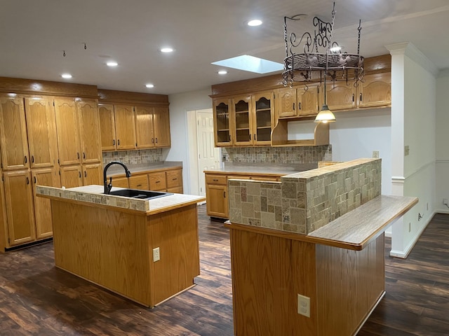 kitchen featuring a sink, tasteful backsplash, a kitchen island with sink, and recessed lighting