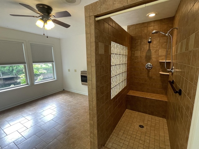 full bathroom with ceiling fan, a tile shower, and baseboards
