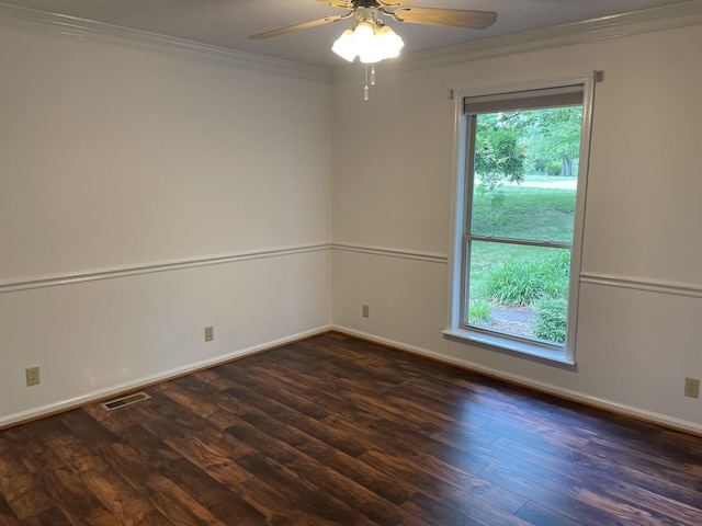 empty room featuring a ceiling fan, visible vents, crown molding, wood finished floors, and baseboards