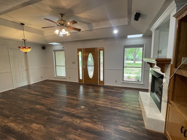 foyer entrance featuring dark wood-style flooring, a premium fireplace, ceiling fan, and a raised ceiling
