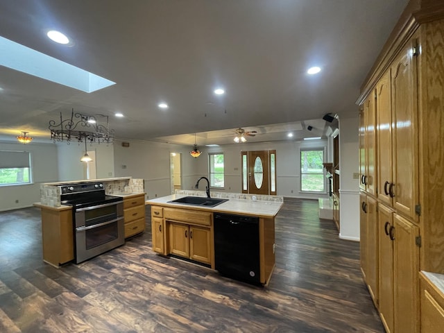kitchen with range with two ovens, a sink, open floor plan, black dishwasher, and an island with sink