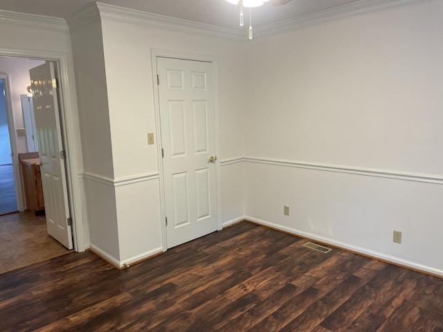 unfurnished room featuring visible vents, ornamental molding, baseboards, and dark wood-style floors