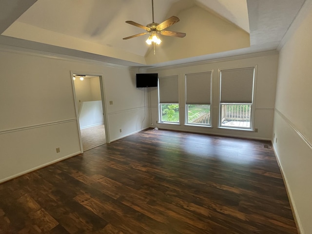 spare room featuring ceiling fan, dark wood finished floors, ornamental molding, and vaulted ceiling
