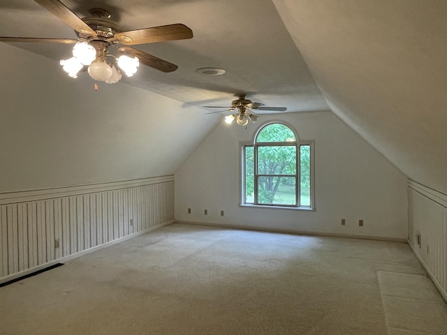 additional living space featuring baseboards, ceiling fan, light carpet, and lofted ceiling