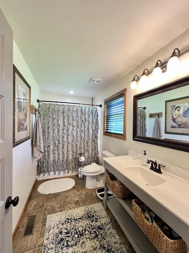 bathroom with visible vents, baseboards, toilet, and vanity