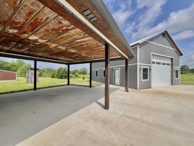 view of patio / terrace with a garage and an outbuilding