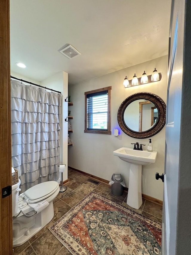 full bath with a shower with curtain, visible vents, a sink, baseboards, and toilet