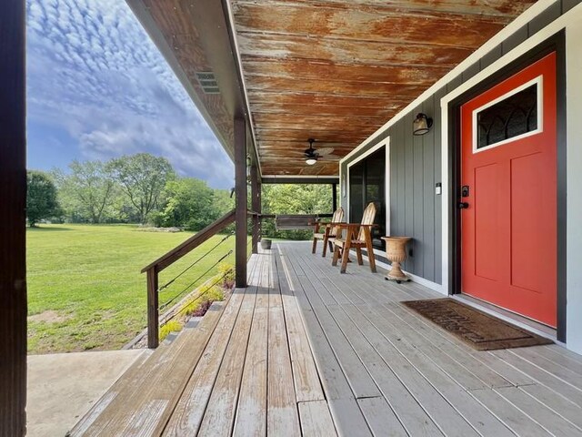 deck with a lawn, ceiling fan, and a porch