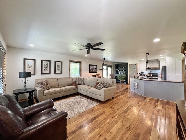 living room with recessed lighting, ceiling fan, and light wood-style floors