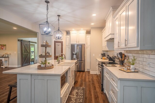 217 Rockhouse Rd, Hohenwald, TN 38462 - kitchen featuring light countertops, tasteful backsplash, stainless steel appliances, and a barn door