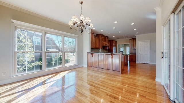 309 New Kent Ct, Tullahoma, TN 37388 - kitchen featuring decorative backsplash, a peninsula, a notable chandelier, ornamental molding, and light wood-style flooring