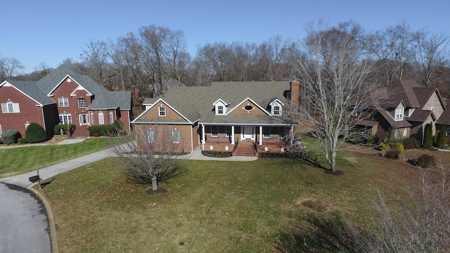 309 New Kent Ct, Tullahoma, TN 37388 - view of front of house featuring covered porch, driveway, a chimney, and a front lawn