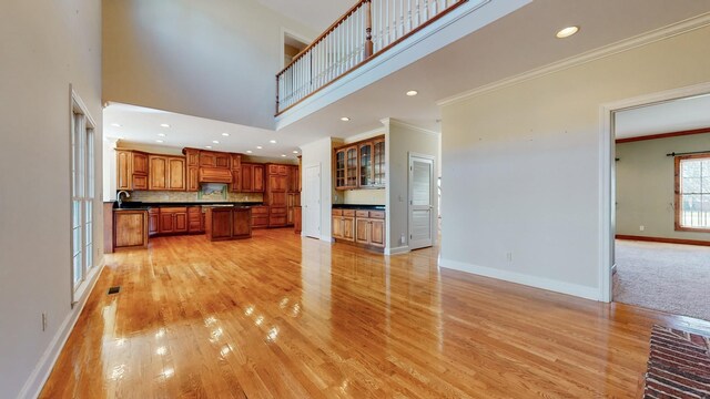 309 New Kent Ct, Tullahoma, TN 37388 - unfurnished living room with visible vents, light wood-type flooring, a high ceiling, baseboards, and ornamental molding