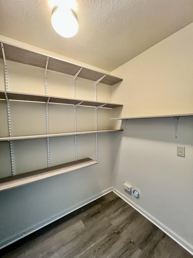 clothes washing area with baseboards and dark wood-style floors