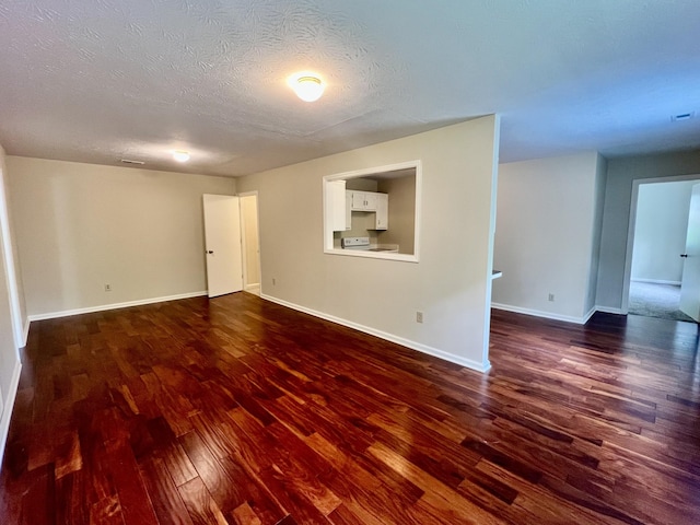 interior space featuring a textured ceiling, baseboards, and dark wood-style floors