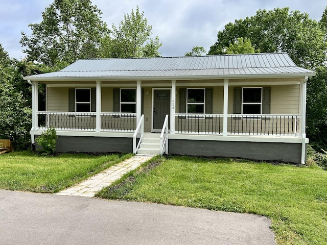 view of front of house with covered porch, a front lawn, and metal roof