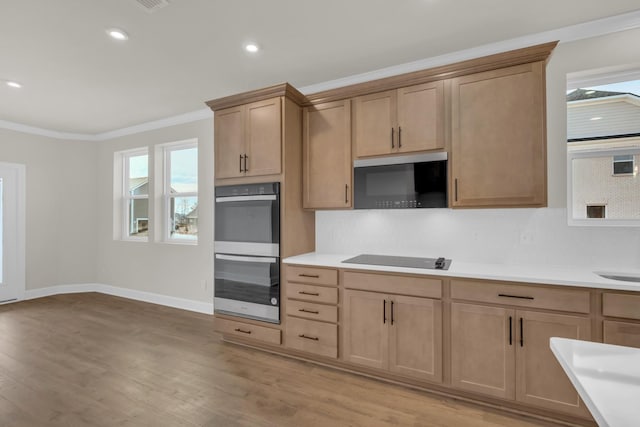 1105 Codah Dr, Mount Juliet, TN 37122 - kitchen with black electric cooktop, ornamental molding, light wood-style flooring, baseboards, and multiple ovens
