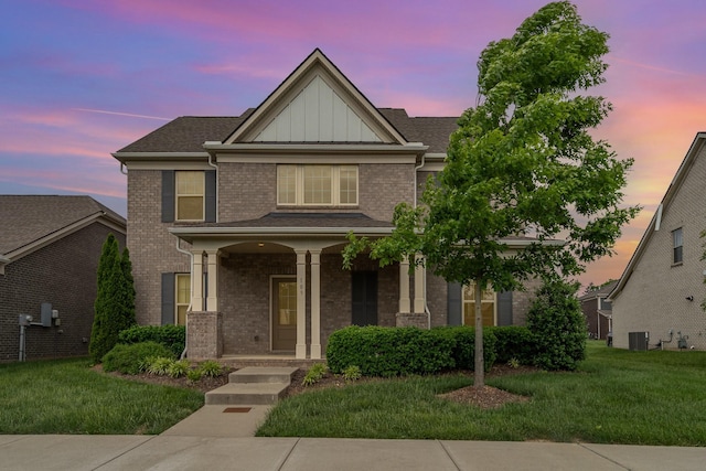 traditional-style home with central air condition unit, board and batten siding, a porch, and a front lawn