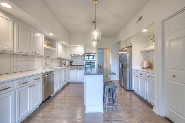 601 Foxborough Sq W, Brentwood, TN 37027 - kitchen featuring appliances with stainless steel finishes, open shelves, a sink, tasteful backsplash, and a breakfast bar
