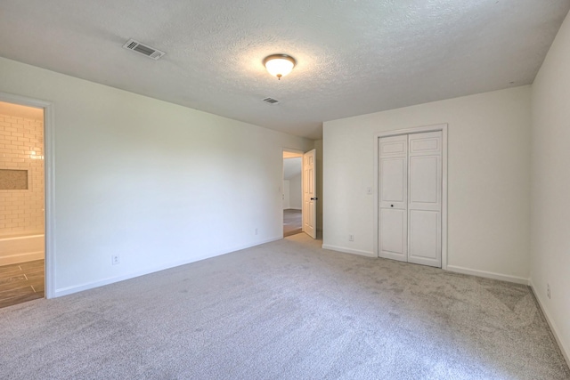 601 Foxborough Sq W, Brentwood, TN 37027 - unfurnished bedroom featuring light colored carpet, a textured ceiling, baseboards, a closet, and connected bathroom