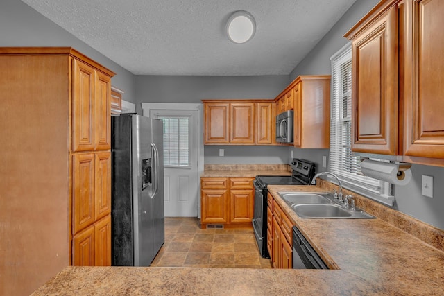 2408 Elliott Dr, Old Hickory, TN 37138 - kitchen featuring stone finish floor, light countertops, a textured ceiling, a sink, and stainless steel appliances