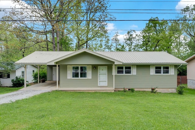 ranch-style home featuring driveway, metal roof, a front yard, and a carport