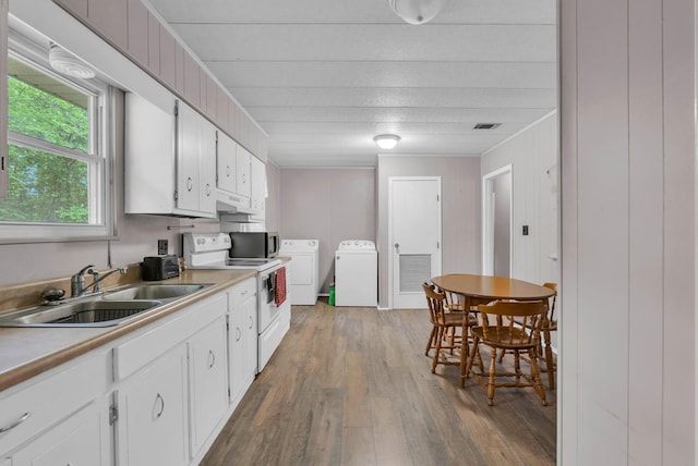 kitchen featuring white electric range oven, a sink, separate washer and dryer, wood finished floors, and under cabinet range hood