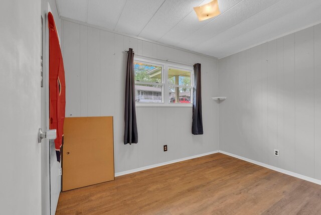 unfurnished room with baseboards and wood finished floors