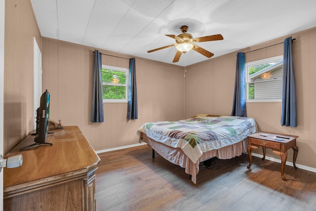 bedroom featuring baseboards, a ceiling fan, and wood finished floors