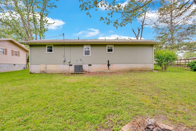 rear view of property with a yard, crawl space, central AC, and fence