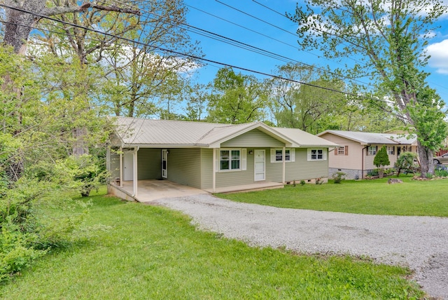 ranch-style house featuring a carport, metal roof, a front lawn, and gravel driveway
