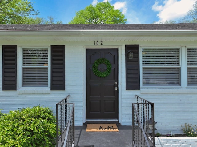 102 Moore Ave, Portland, TN 37148 - doorway to property with roof with shingles and brick siding