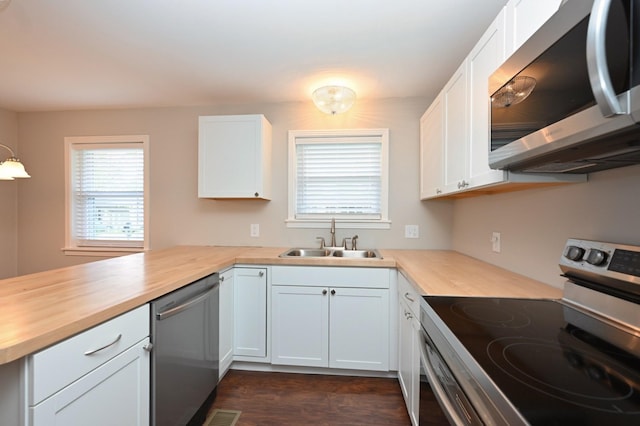 102 Moore Ave, Portland, TN 37148 - kitchen with wooden counters, appliances with stainless steel finishes, a sink, white cabinets, and a peninsula