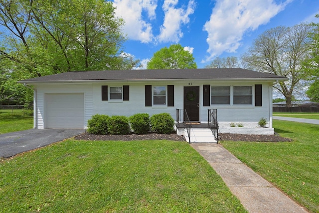 102 Moore Ave, Portland, TN 37148 - ranch-style house featuring an attached garage, driveway, brick siding, and a front yard