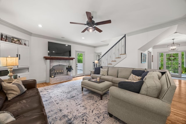 6437 Arno Rd, College Grove, TN 37046 - living area with a ceiling fan, a fireplace with raised hearth, ornamental molding, light wood-style flooring, and a chandelier