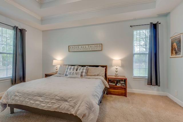 bedroom with carpet floors, ornamental molding, baseboards, and a tray ceiling