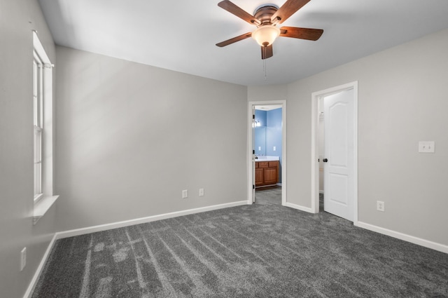 990 Iron Hill Rd, Burns, TN 37029 - unfurnished bedroom featuring dark colored carpet, baseboards, ensuite bath, and a ceiling fan