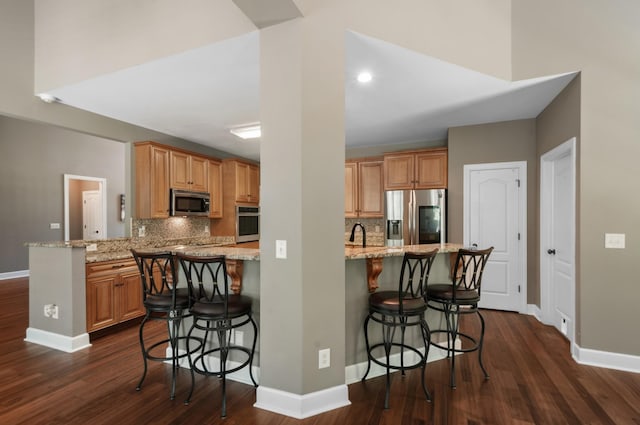 990 Iron Hill Rd, Burns, TN 37029 - kitchen featuring stainless steel appliances, a peninsula, baseboards, and dark wood-style floors